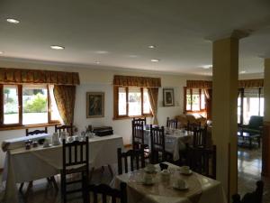 un comedor con mesas, sillas y ventanas en Hotel Mara en Miramar