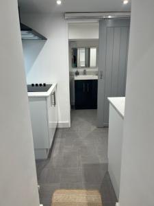 een keuken met witte kasten en een tegelvloer bij Harbour Apartment in Barmouth