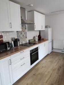 a kitchen with white cabinets and a wooden floor at Seashells in Bridlington