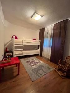 - une chambre avec des lits superposés blancs et un tapis dans l'établissement Soko holiday home Bihac, à Bihać