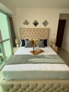 een slaapkamer met een groot bed en een groot raam bij Ecusuites Studio Two Riverfront con Jacuzzi Hidro Privado in Guayaquil