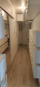una stanza vuota con armadi bianchi e pavimento in legno di logement chambre seul sur ou dortoir mixte a Roquemaure