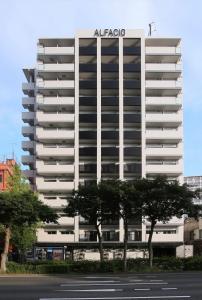 - un grand bâtiment blanc avec un panneau acoco dans l'établissement ROID HOTEL HAKATA, à Fukuoka