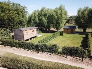 een klein gebouw in een tuin met een heg bij Camping des Saules in Jurbise