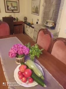 un tavolo con un piatto di verdure e un vaso di fiori di Casa vacanza Todi Antica a Todi