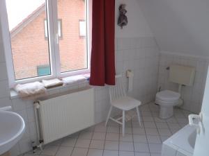 a bathroom with a toilet and a sink and a window at Triton II in Hohwacht