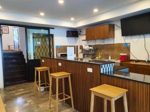 kuchnia z drewnianymi stołkami i blatem w obiekcie Grace Seaview บ้านพักส่วนตัว 3 ห้องนอน วิวทะเล หาดพลา w mieście Ban Phala