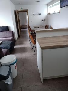 a kitchen and living room with a couch and a counter at Het Logie Moment in Langemark