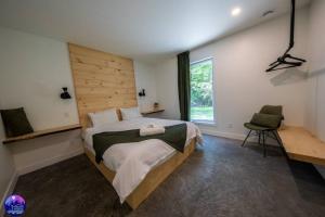 um quarto com uma cama grande e uma janela em Chalet Forestria - SPA- Billard- Ski em Mansonville