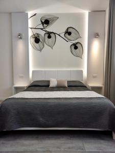 um quarto com uma cama com um ramo com folhas em La Brise em Marina di Pietrasanta