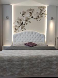 a bedroom with a large bed with a white headboard at La Brise in Marina di Pietrasanta