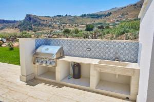 cocina al aire libre con parrilla y fogones en VILLA DEL BORGO con piscina e jacuzzi, en Scopello