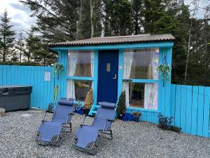 un edificio azul con sillas delante en Bankhead Accommodation with Hot Tub Aberdeenshire, en Gamrie