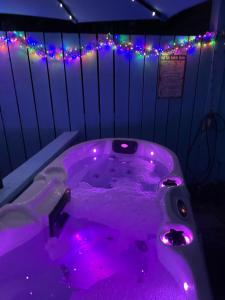a purple bath tub with purple lights in a room at Bankhead Accommodation with Hot Tub Aberdeenshire in Gamrie
