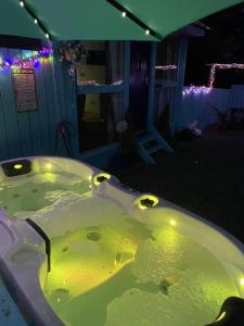 a bath tub in a yard at night with lights at Bankhead Accommodation with Hot Tub Aberdeenshire in Gamrie