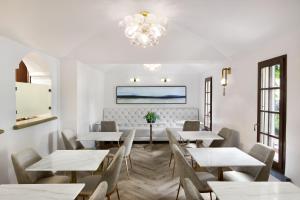 a dining room with tables and chairs and a chandelier at Kenwood Inn & Spa in Kenwood