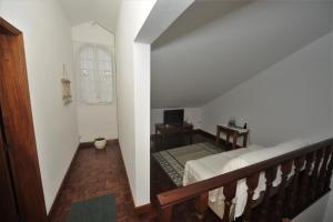 a room with a bed and a staircase with a mirror at Casa da Salga in Angra do Heroísmo