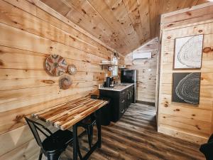 a log cabin kitchen with a wooden wall at Cabin #8 Studio With Kitchenette in Hartwell