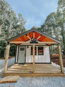 a small shed with a roof and a porch at Cabin #9 One Bedroom W Kitchenette in Hartwell