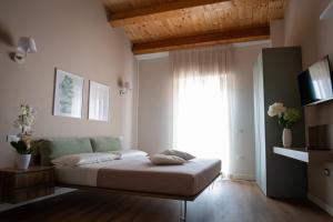 a bedroom with a bed and a large window at Dimora Donna Dora - Albergo Diffuso in San Martino in Pensilis