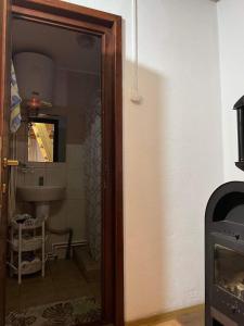 uma porta que dá acesso a uma casa de banho com um lavatório em Csillag kulcsoshaz em Gheorgheni