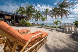 krzesło na plaży z palmami i budynek w obiekcie Holiday Hotel w mieście San Pedro