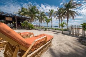 a chair on a beach with palm trees and a building at Holiday Hotel in San Pedro