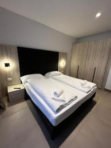 1 dormitorio con 1 cama grande con sábanas blancas en Bilo - Apartments for rent en Trento