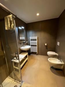 a bathroom with two sinks and a shower and a toilet at Bilo - Apartments for rent in Trento