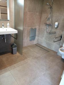 La salle de bains est pourvue d'une douche et d'un lavabo. dans l'établissement Het Logie Moment, à Langemark