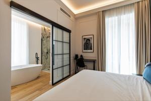 a bedroom with a bath tub and a large mirror at Unico Relais in Naples