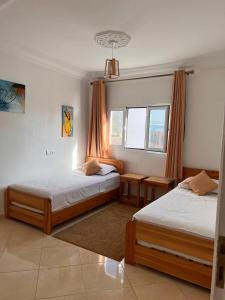 1 dormitorio con 2 camas y ventana en Dar Surf, en Taghazout