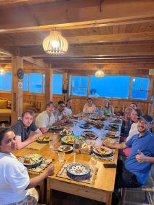 een groep mensen die rond een tafel eten bij Dar Surf in Taghazout