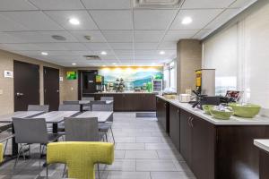 a restaurant with tables and chairs in a cafeteria at Quality Inn Asheville Downtown Tunnel Rd in Asheville