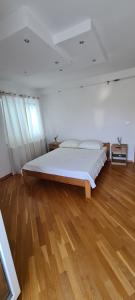 a bedroom with a large bed and a wooden floor at Apartman Marija in Korčula