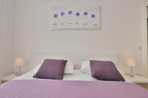1 dormitorio con 1 cama de color púrpura y 2 almohadas de color púrpura en Eden Penthouse Apartments, en Zadar