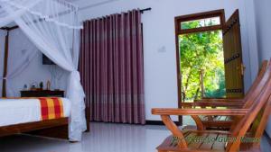 a bedroom with a bed and a window at The Cattleya Guest House in Sigiriya