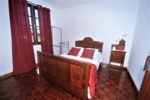 Schlafzimmer mit einem Bett mit weißer Bettwäsche und roten Kissen in der Unterkunft Casa da Salga in Angra do Heroísmo