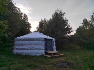 a blue yurt with a table in a field at Jurta Ve Hvozdech in Blansko