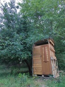 a wooden outhouse in a field with trees at Jurta Ve Hvozdech in Blansko