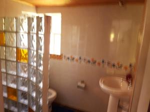 a bathroom with a sink and a toilet at Cabañas Yukatan Lago de Tota in Tota