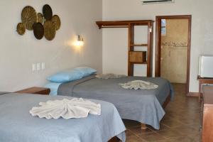 two beds in a hotel room with towels on them at Holiday Hotel in San Pedro