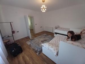 een klein meisje op een bed in een kamer bij Vila Dervish ÇELA - MOKER in Pogradec