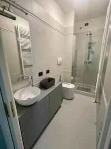 a white bathroom with a sink and a shower at Appartamento IL CUSCINO DELLA SUOCERA in Foiano della Chiana