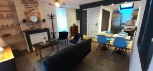salon z kanapą, stołem i krzesłami w obiekcie Le GENISTA w mieście Angers +5 zdjęć