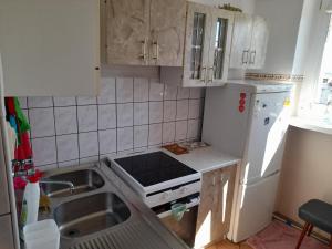 a kitchen with a sink and a white refrigerator at APARTAMENT LAZUROWY in Władysławowo