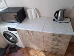 cocina con microondas y cafetera en una encimera en APARTAMENT LAZUROWY en Władysławowo