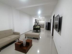 sala de estar con sofá y mesa en Departamento Suite Ciudad del Mar, en Manta