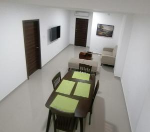 comedor con mesa, sillas y sofá en Departamento Suite Ciudad del Mar, en Manta