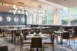 丹佛The Slate Hotel Denver Downtown, Tapestry by Hilton的有桌椅和窗户的餐厅